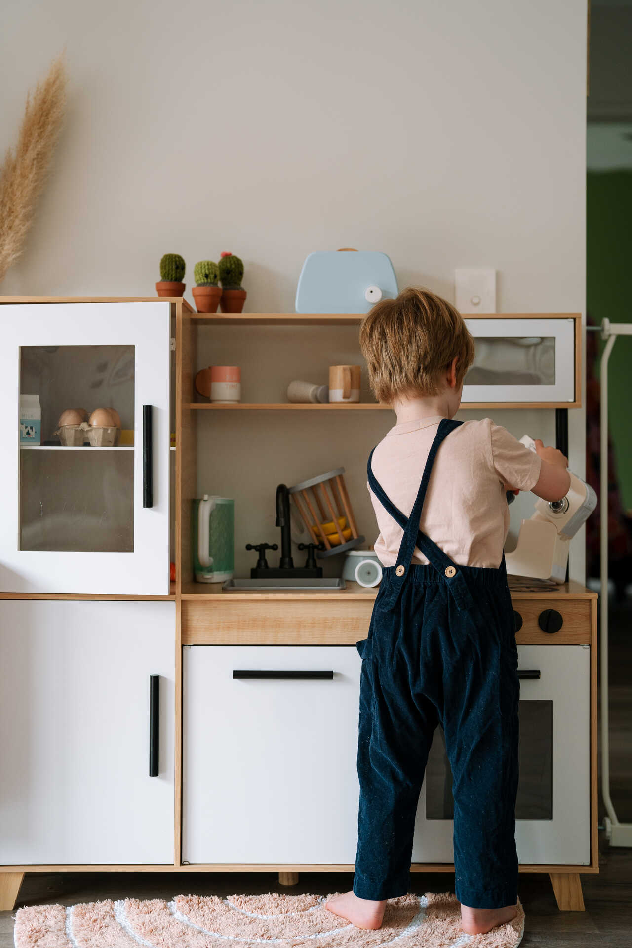 Child plays with a toy kitchen