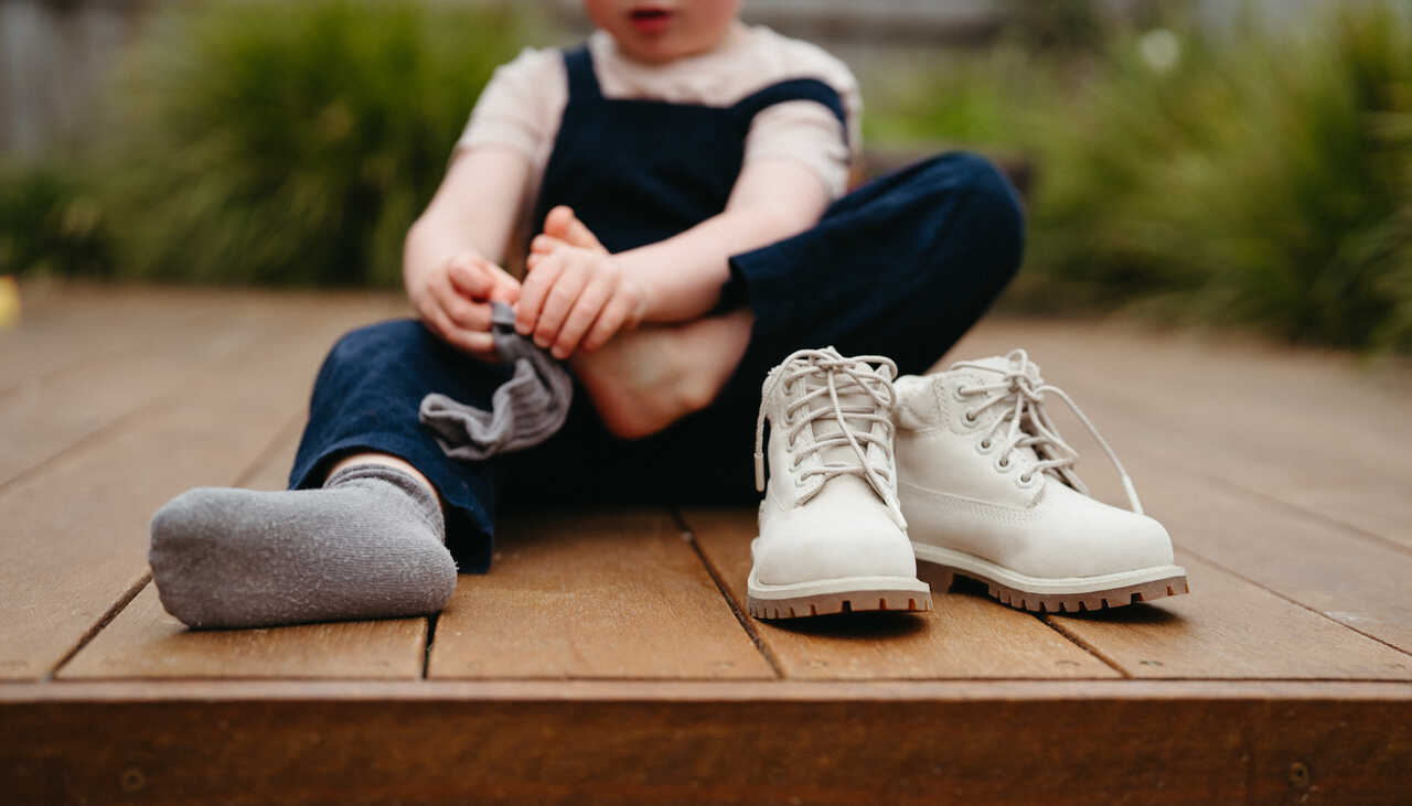 Child learns to put shoes and socks on