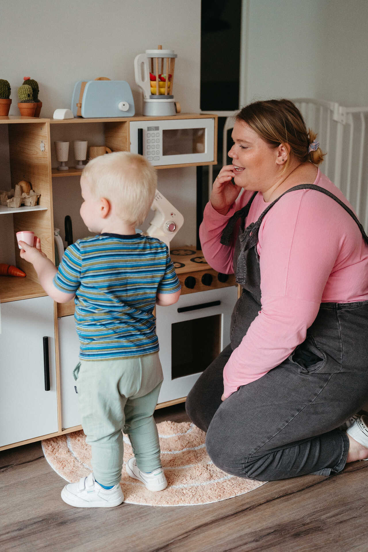 Child and behaviour technician play pretend with kitchen