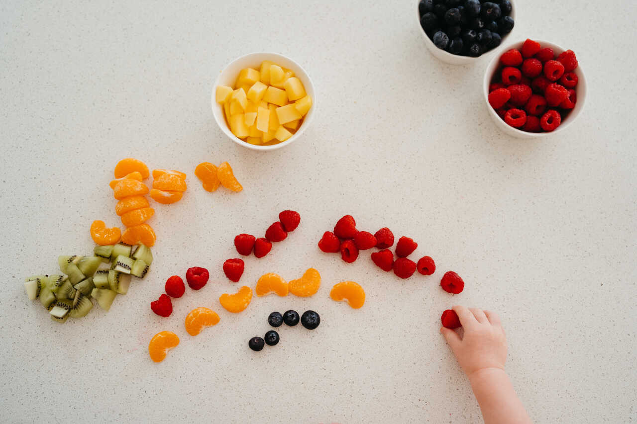 Child creates a fruit rainbow